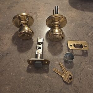 Kwikset Tylo Keyed Entry Door Knob in a polished brass finish.